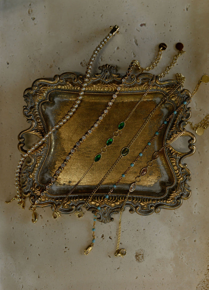 Assorted gold bracelets on a gold jewelry tray