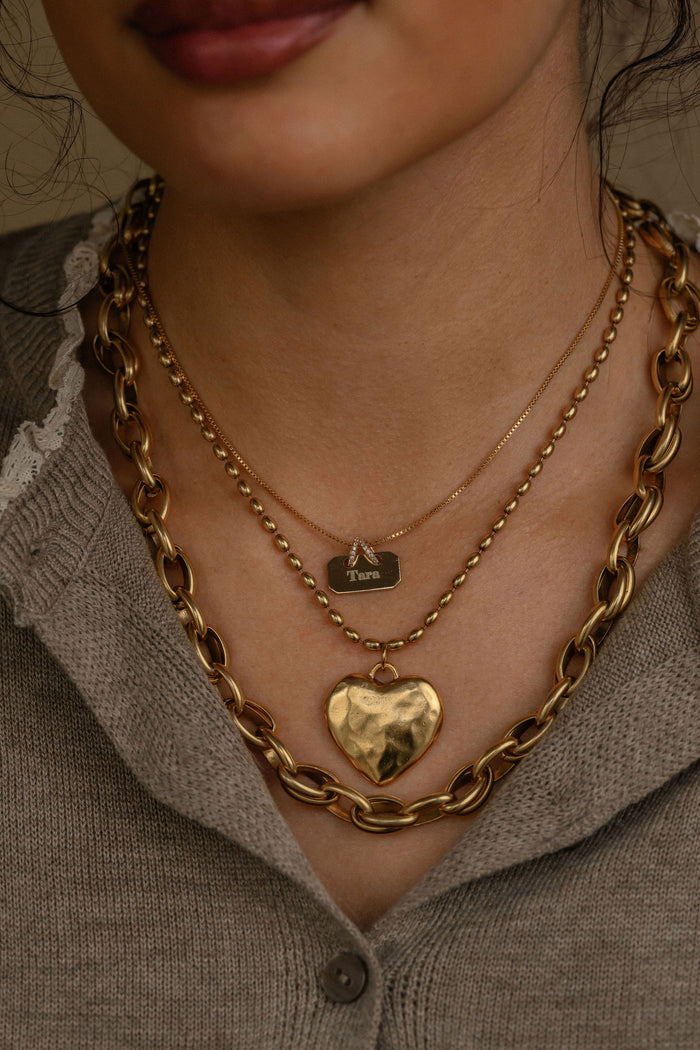 Cherie necklace featuring a dimensional gold heart pendant on a dainty chain