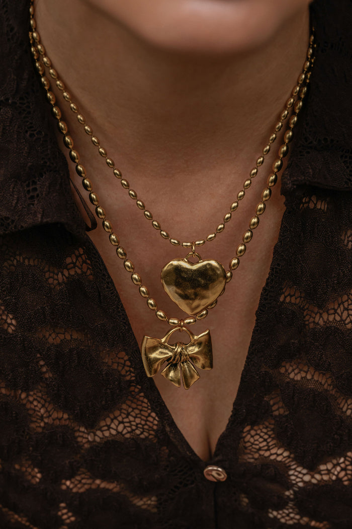 Gold heart pendant from the Cherie necklace, shown with its chain