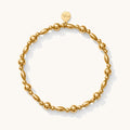 Close up of a gold bead bracelet on a white background