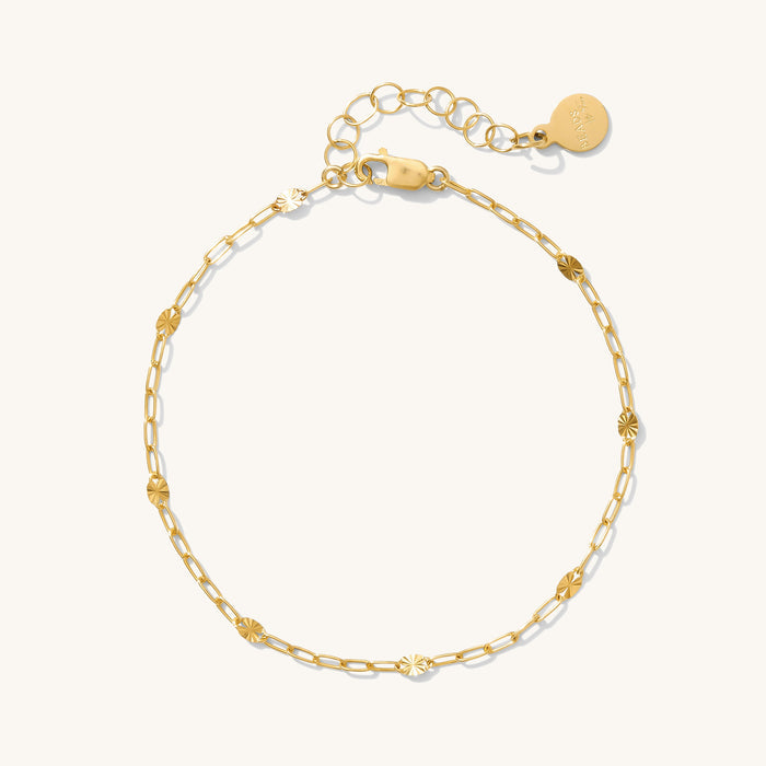Close up of a gold chain bracelet on a white background