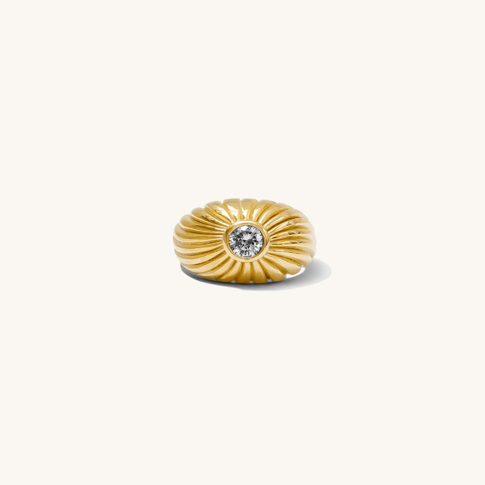 Close up of the gold Comet dome ring and its center stone on a white background