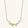 Sculptural gold Contour charm necklace with a curved, textured silhouette