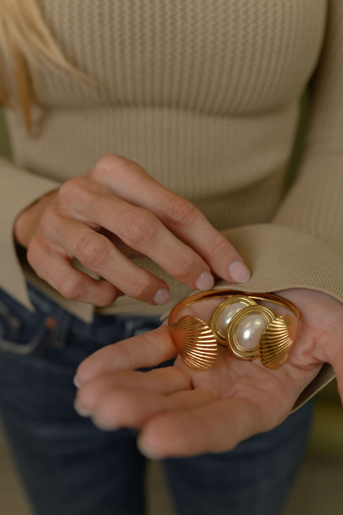 A woman holding a bracelet and pair of earrings
