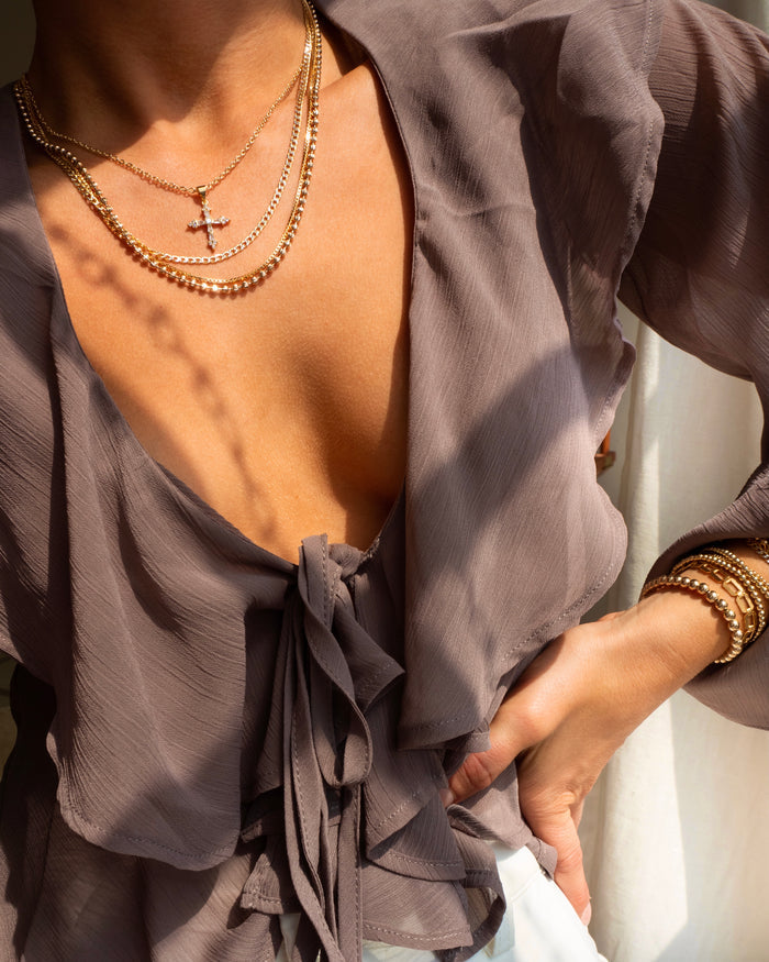Cruz statement necklace styled on the neckline in 14k gold plate