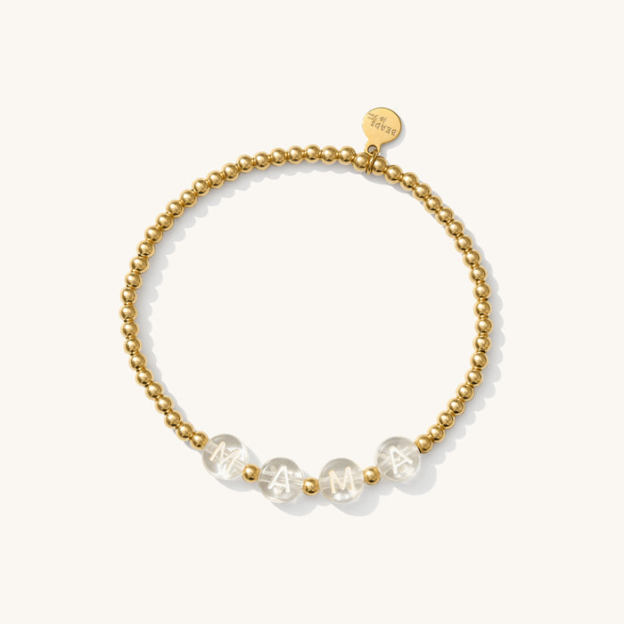 Close up of a gold bead bracelet with clear letter beads reading "MAMA"