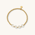 Close up of a gold bead bracelet with clear letter beads reading "MAMA"