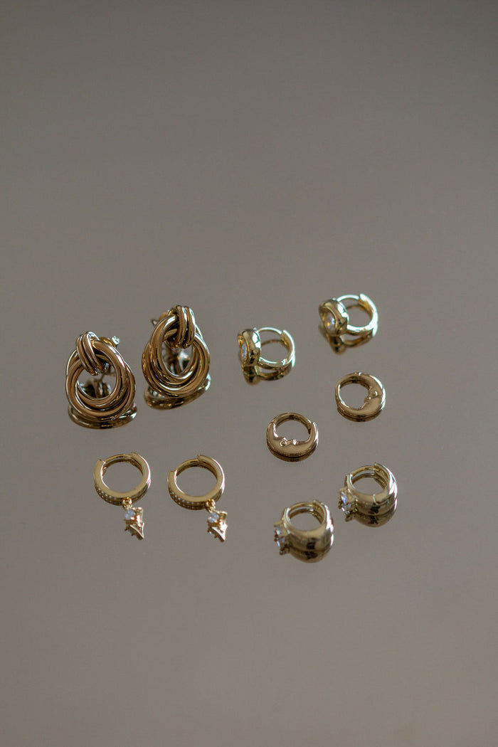 Shot of five pairs of small hoop earrings on a grey background