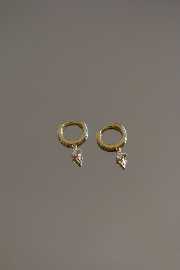Shot of a pair of small hoop earrings with stone accents on a grey background
