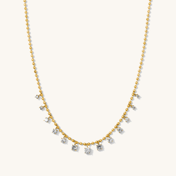 Close up of the gold Diamond Rain necklace on a white background