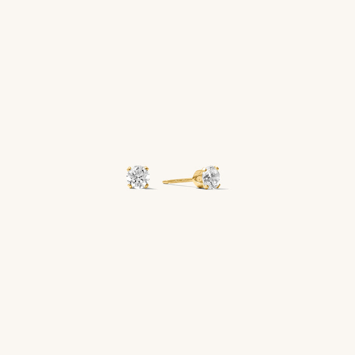 Close up of gold stone studs on a white background