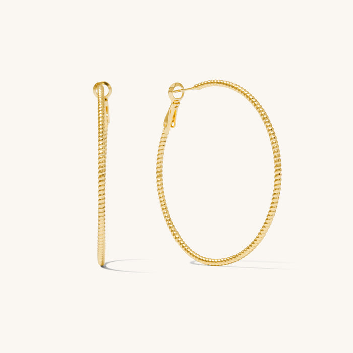 Close up shot of textured hoop earrings on a white background