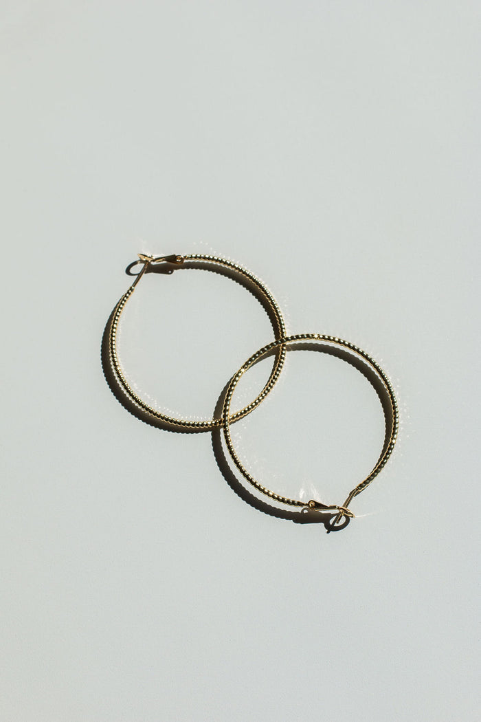 Close up shot of hoop earrings on a neutral background