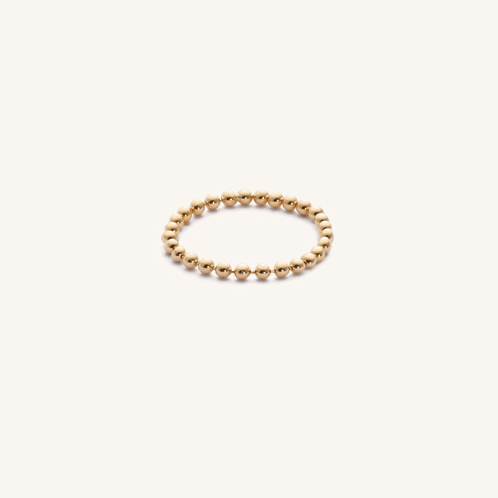 Close up of the gold Dottie chain ring on a white background