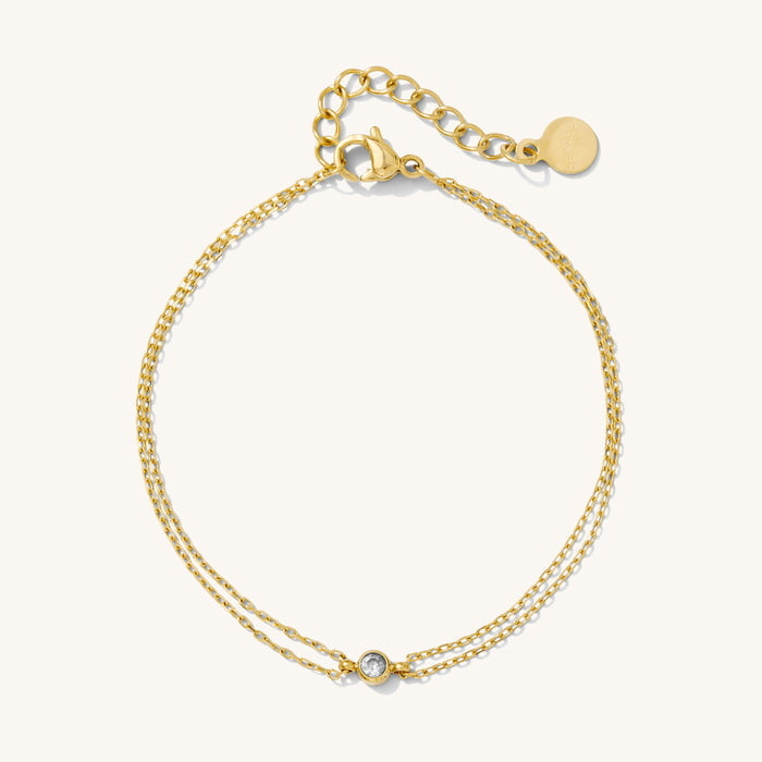 Close up of a gold bracelet on a white background