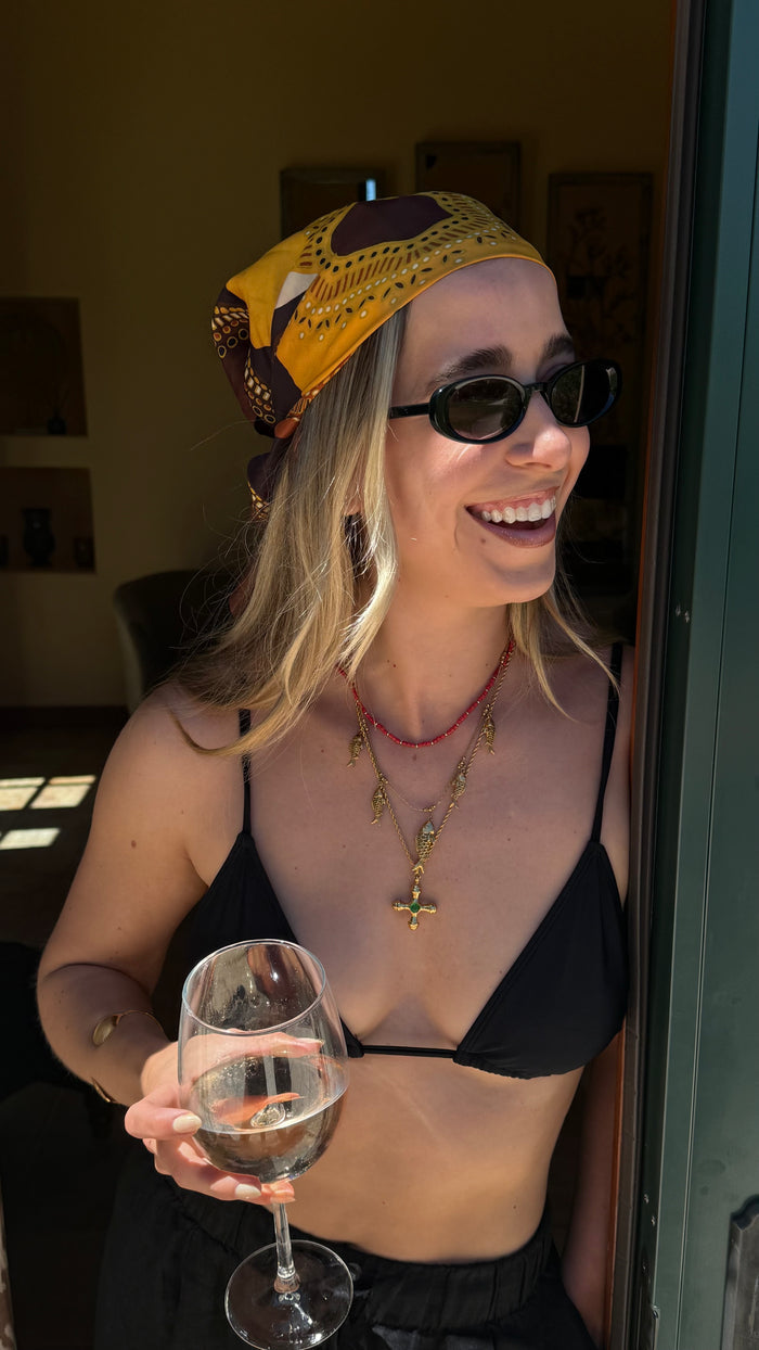 The gold Dune necklace with an emerald center stone from Beads by Tara