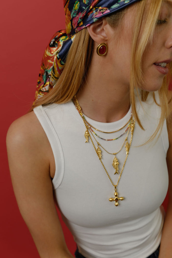 Studio close up of the gold Dune necklace with a tiger's eye center stone on a white background