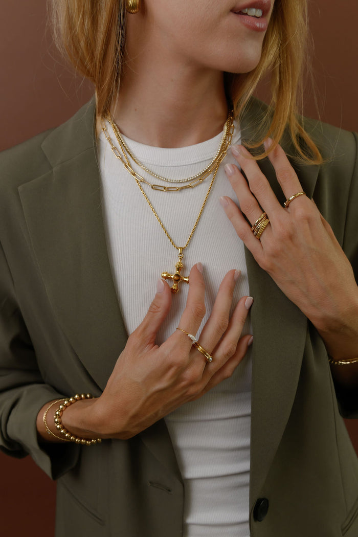 Close view of the gold Dune necklace with a tiger's eye center stone on a white background