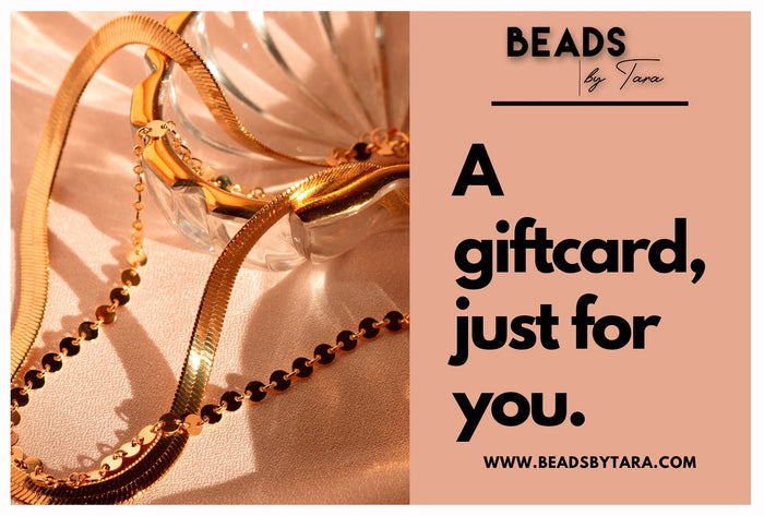 A photo of gold jewelry on a pink background next to text that reads "Beads by Tara - A gift card, just for you. beadsbytara.com"