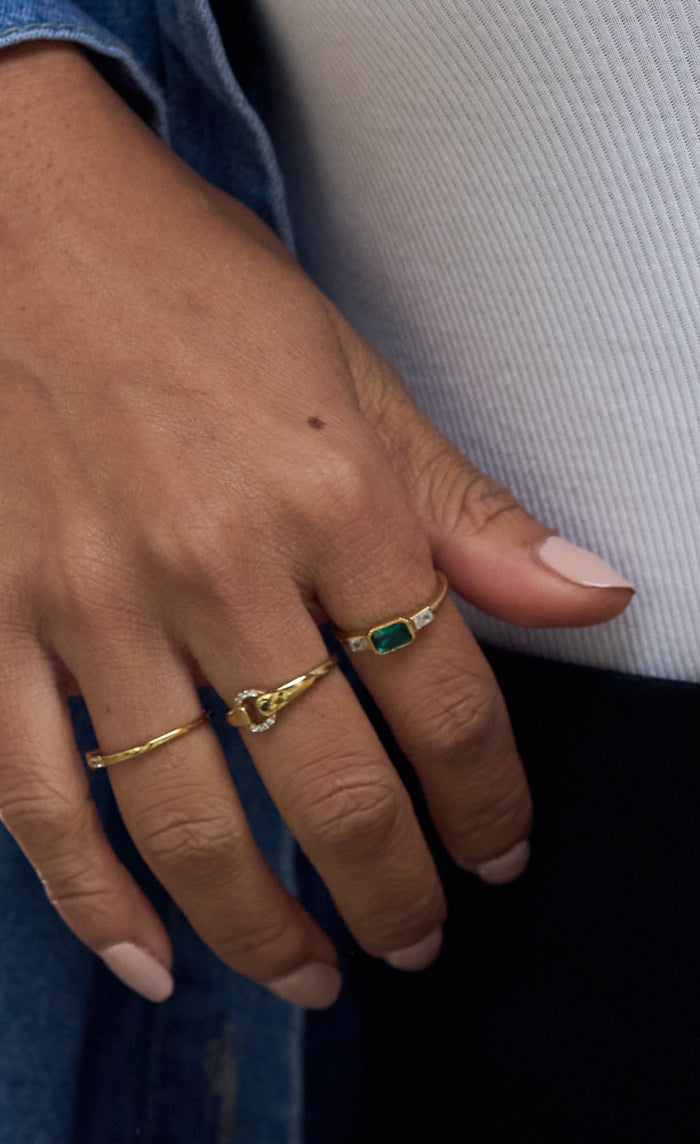 East West Emerald ring detail showing its side stones and sculpted bezel