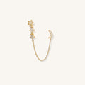 Close up of a star and moon shaped double piercing earring on a white background