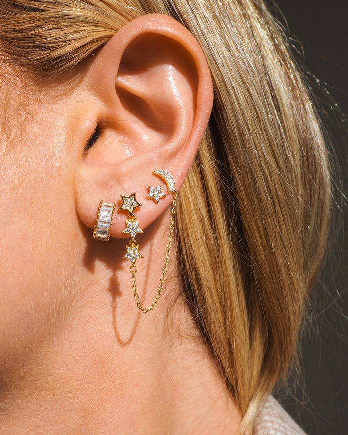 Close-up of an ear with multiple crystal earrings