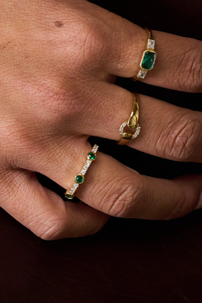 The gold Emerald Drop ring, green stones separated by a line of pavé crystals