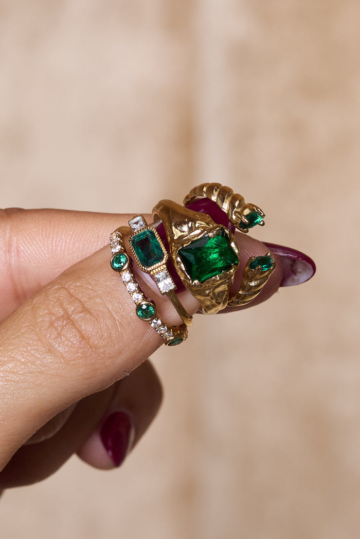The Emerald Drop ring showing its dropped green stones along a gold band