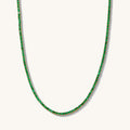 Close up of the gold Emerald Everyday tennis necklace on a white background