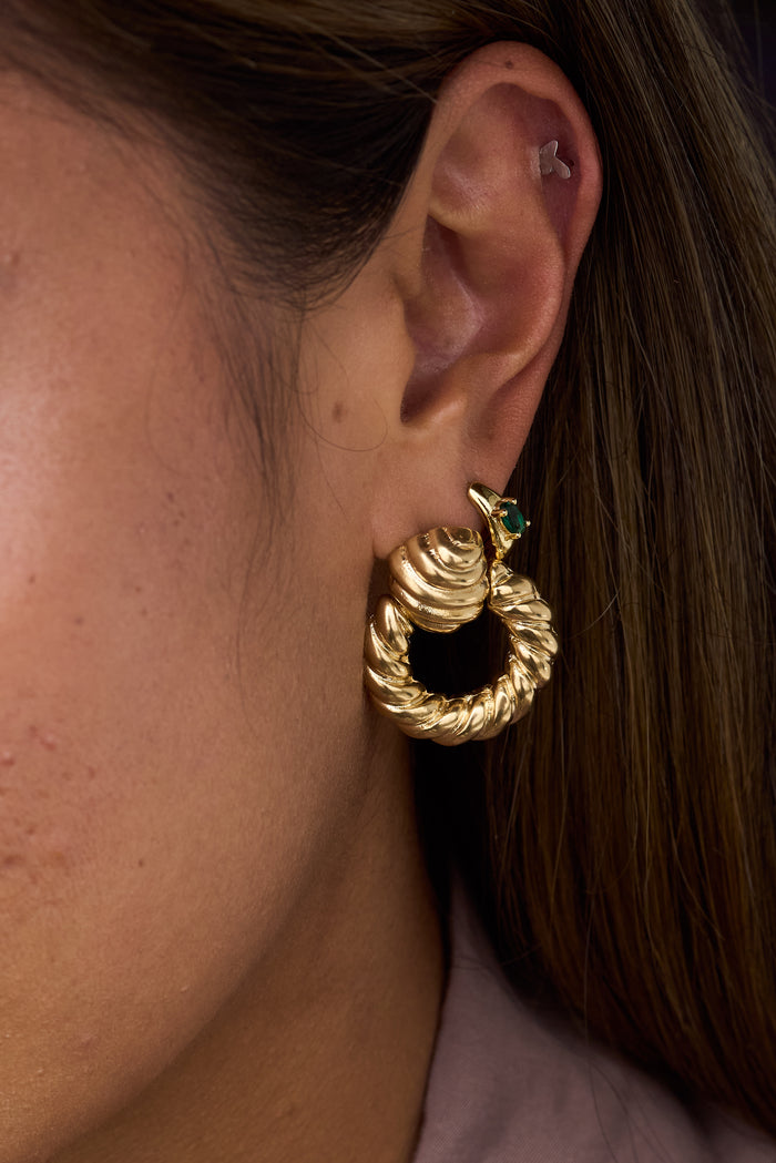 Close-up of an ear with multiple gold earrings