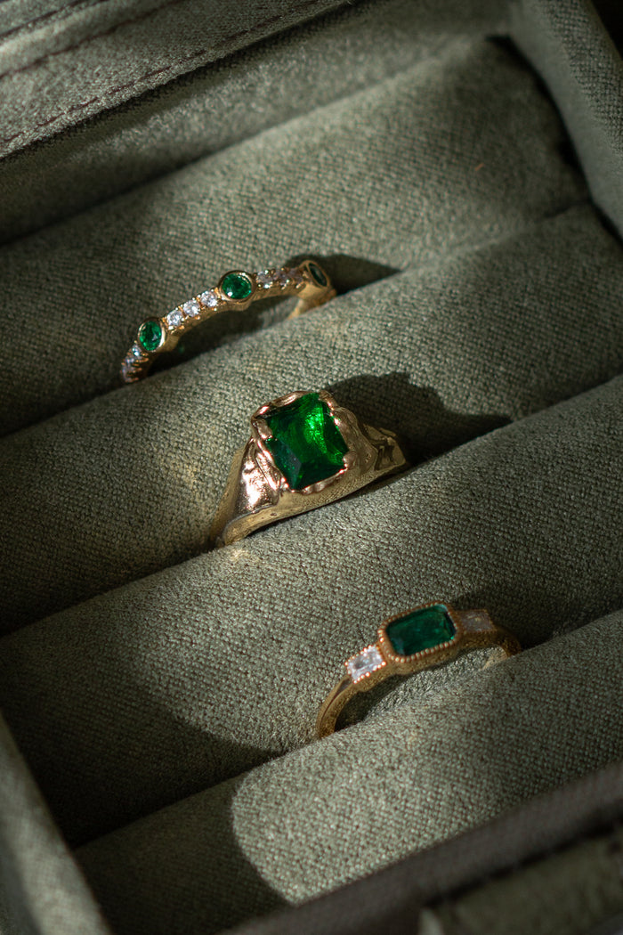 Molten gold setting wrapping the rectangular emerald of the Empress ring
