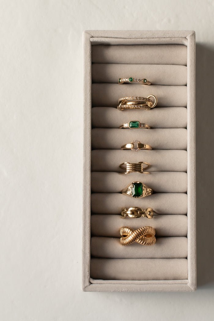 Gold Empress ring with an emerald-toned rectangular stone and organic band