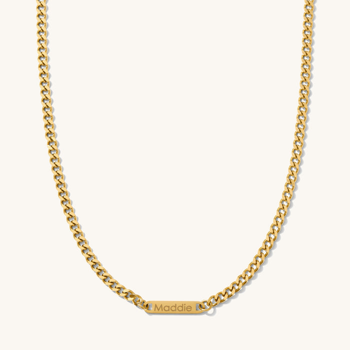 Close up of the engraved Cuban bar necklace on a white background