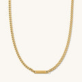 Close up of the engraved Cuban bar necklace on a white background
