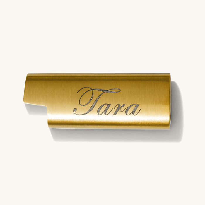 Close up of the gold engraved lighter cover on a white background