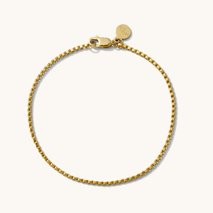 Close up of a gold chain bracelet on a white background