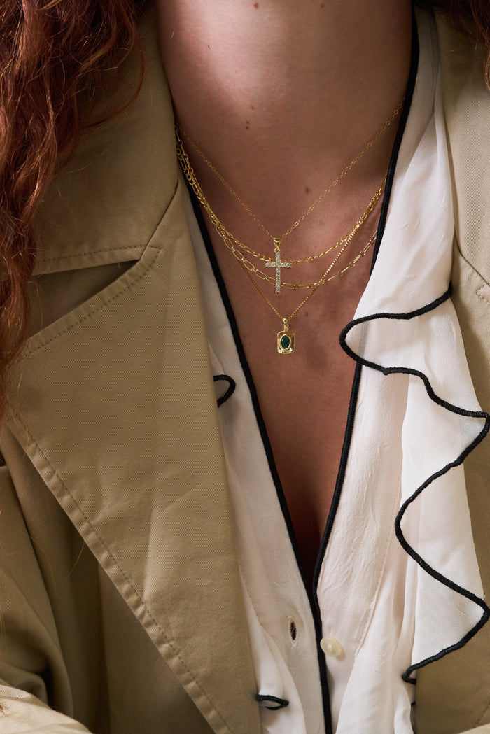 The Everyday Cross necklace, a simple gold cross that layers with any pendant