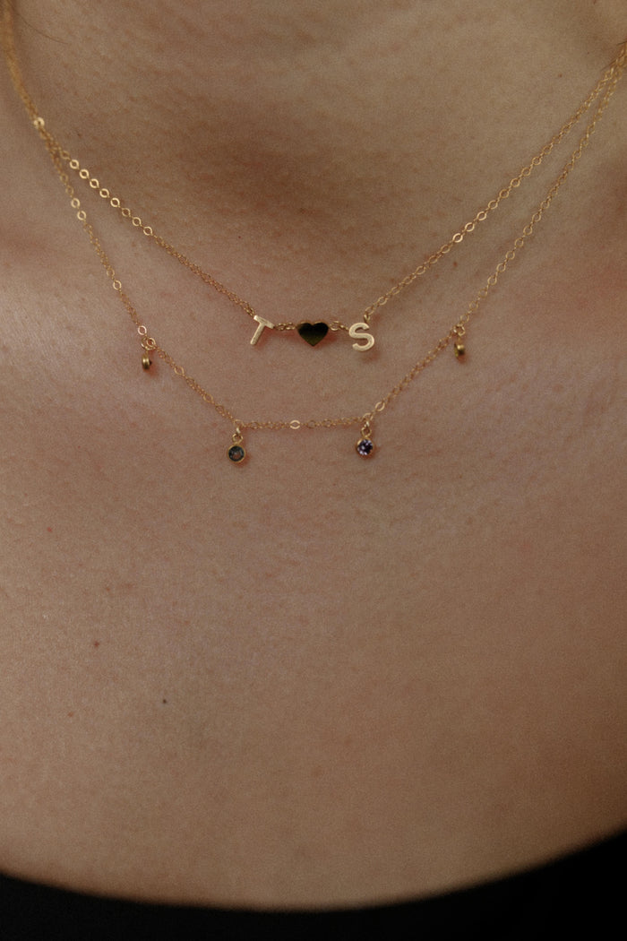 Close up of the gold Everyday Initial necklace on a white background