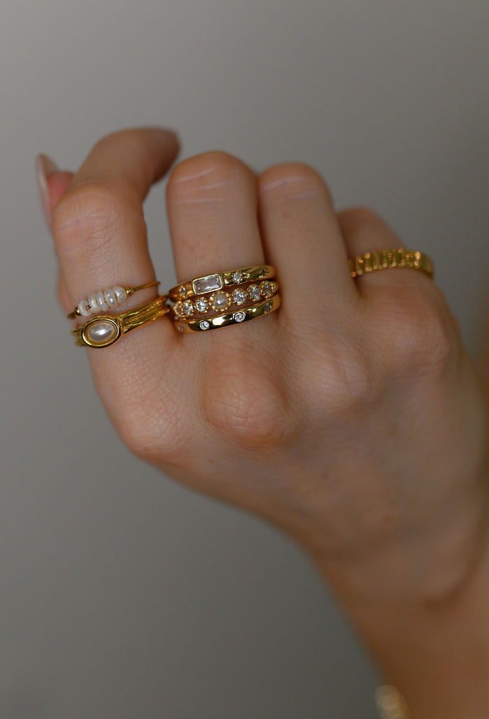 The gold Fleur de Sel pearl ring photographed on a white background