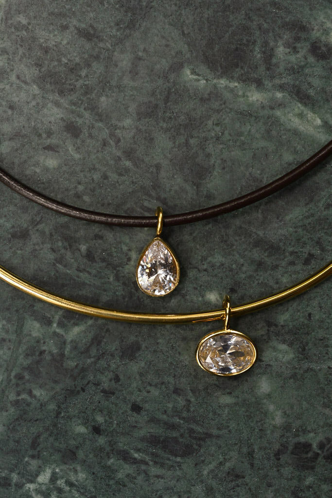 Sleek gold collar necklace with a bezel set cubic zirconia pendant