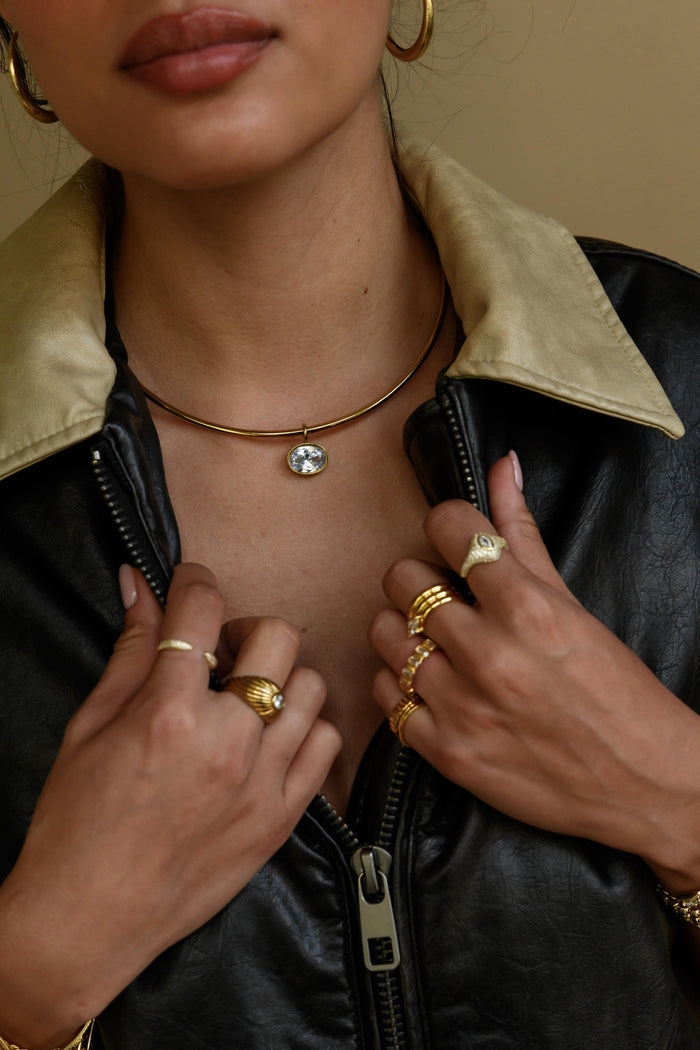 A minimal gold collar necklace with a removable stone pendant