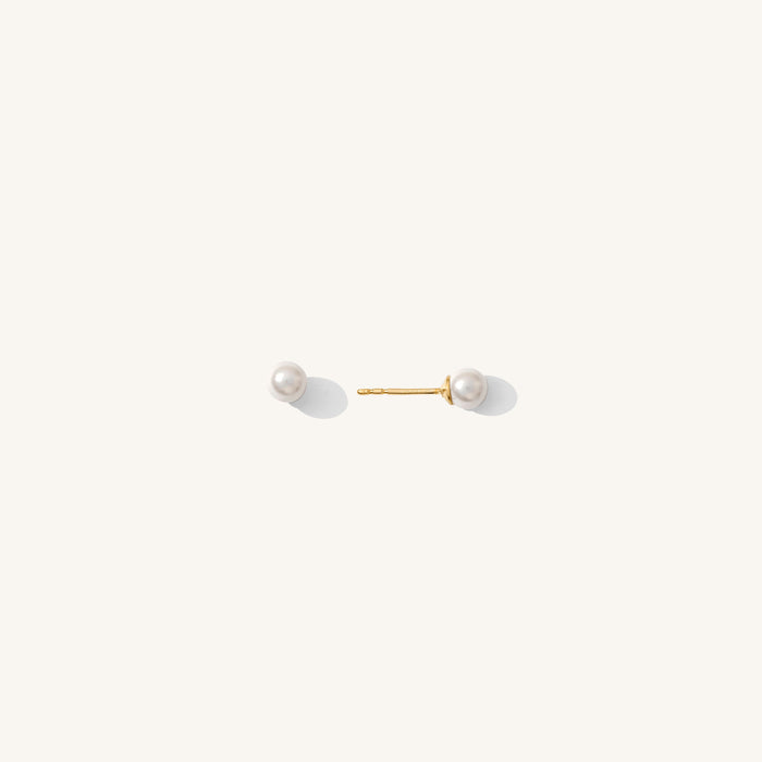Close up of pearl stud earrings on a white background