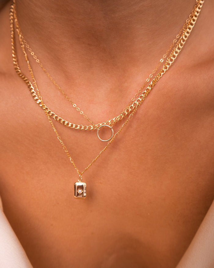 The Full Circle necklace worn layered with other dainty chains