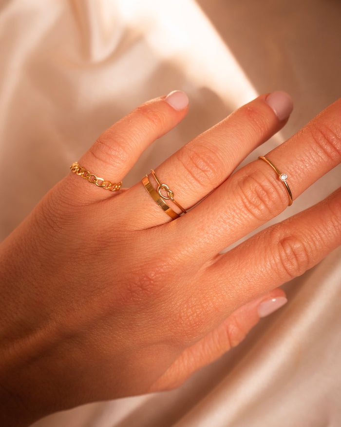 The Gemma stone ring worn on the hand in a dainty gold stack