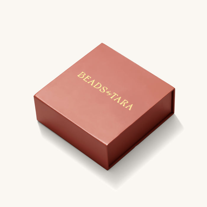 Close up of the coral gift box with its inlaid mirror on a white background