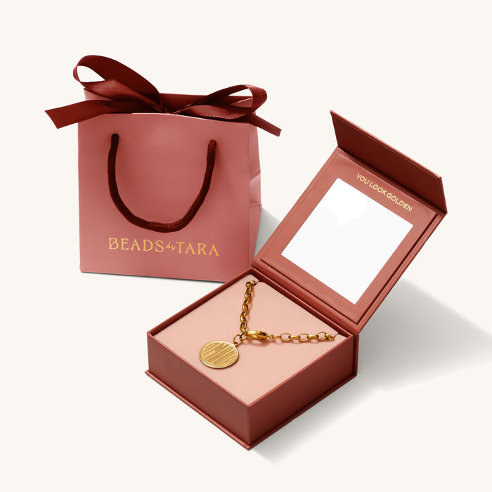 Close up of the gift box set with its matching ribbon-tied bag on a white background