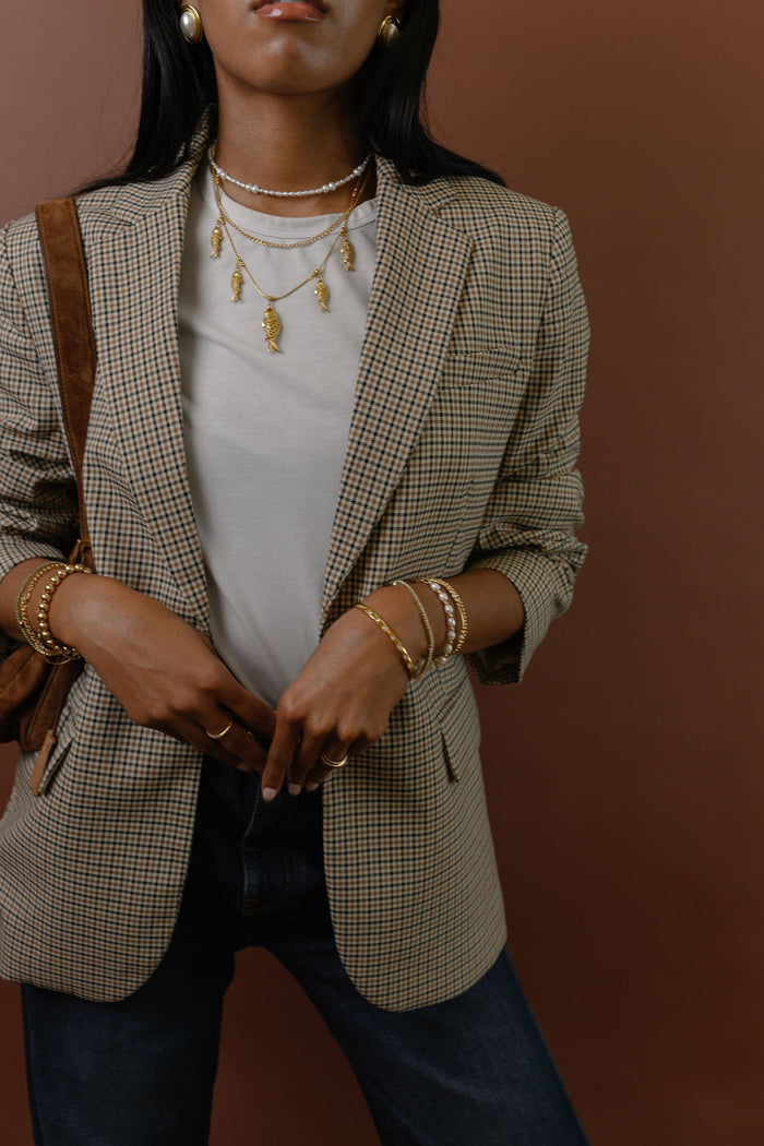 Studio close up of the gold Go Fish statement necklace on a white background