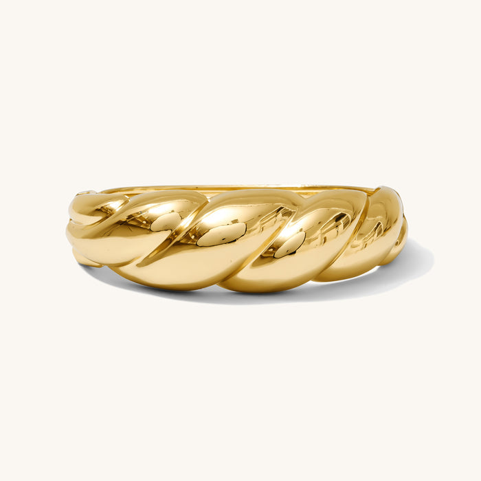 Close up of gold bangle bracelet on white background