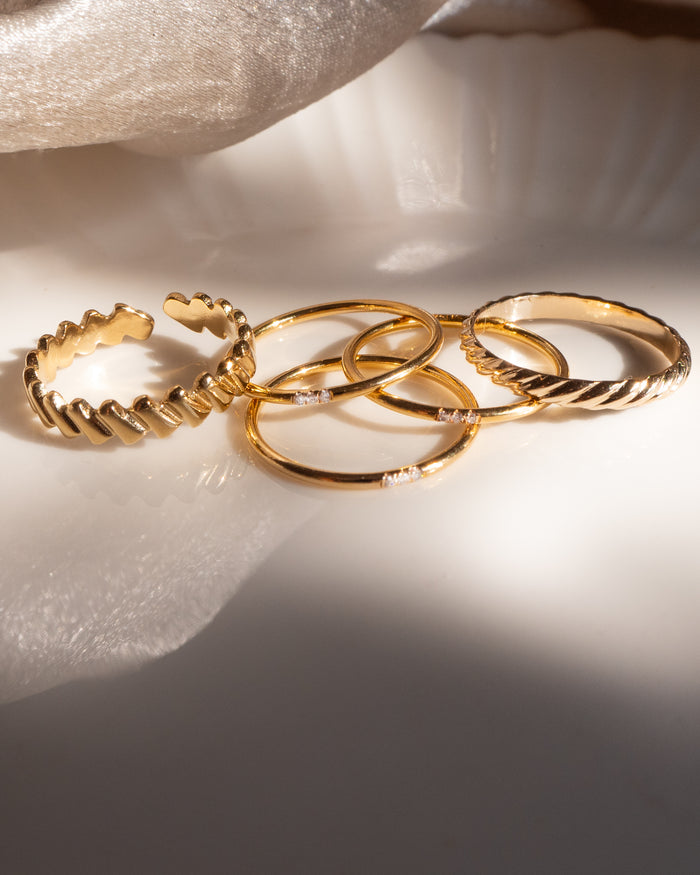 Model wearing the twisted gold Goldie ring stacked on the hand
