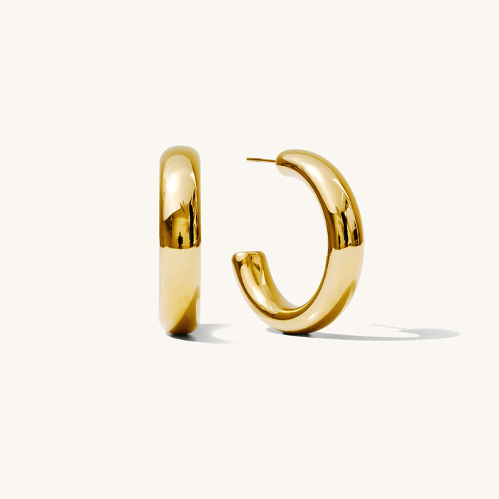 Close up of gold hoops on a white background